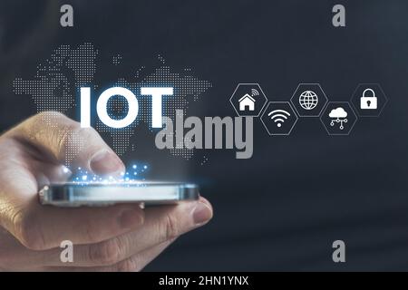 Concept IOT or Internet of Things. A technology for transferring data between different objects. Hologram over a smartphone in the hands of a person w Stock Photo