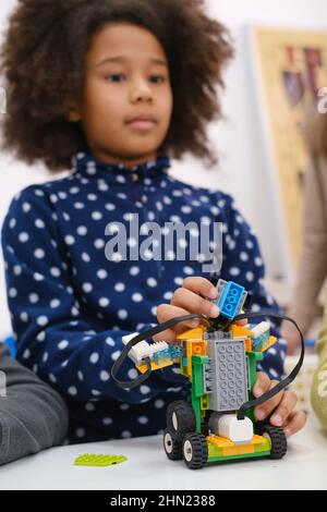 Kids learning coding, science and technology at school class. African American and Caucasian children studding with laptop computers on STEM lesson Stock Photo