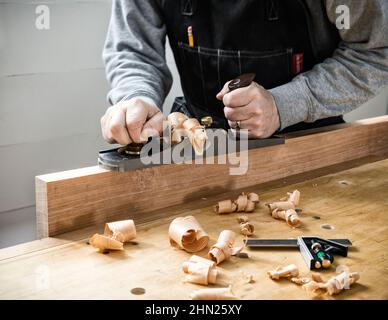 Woodworker hand planing with a low angle Jack Plane. Stock Photo