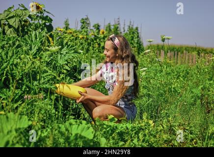 Helping in garden. happy childrens day. childhood happiness. portrait of happy kid with vegetable marrow. cheerful retro child hold big marrow squash Stock Photo