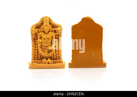 The statue of Venkateswara Swamy carved in brown wood is insulated with white on the front and back. Stock Photo