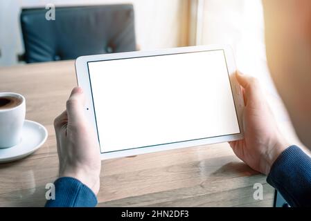 Tablet in hands mockup. Coffee shop desk Stock Photo