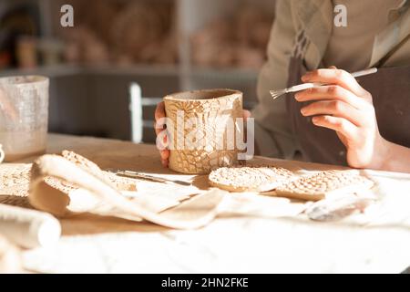 Close up of hands of unrecognizable woman making ceramic mug at pottery stusio Stock Photo