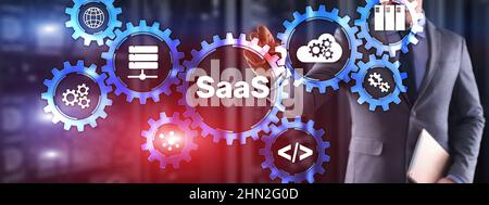 SaaS Software as a Service concept with hand pressing text. Stock Photo