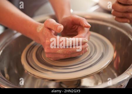 Close up of female hands working on pottery wheel Stock Photo