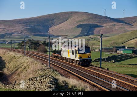 Class 92 electric locomotive hauling a short freight train of 1 steel wagon at Crawford in the upper Clyde valley on the west coast mainline, Scotland Stock Photo