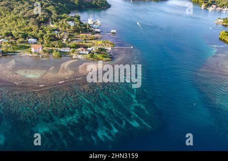 An aerial view of a channel on the island of Roatan shows the reef leading up to a shelf of homes lived in by the wealthy. Stock Photo