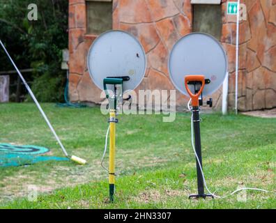 Two television dishes mounted on garden forks in a camping ground Stock Photo