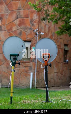 Two television dishes mounted on garden forks in a camping ground Stock Photo