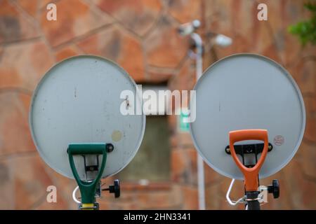 Two television dishes mounted on garden forks in a camping ground Stock Photo