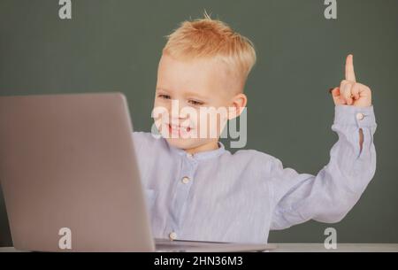 Amazed child using gadgets to study. Computer education for kids. Genius child programming, computer training. Stock Photo
