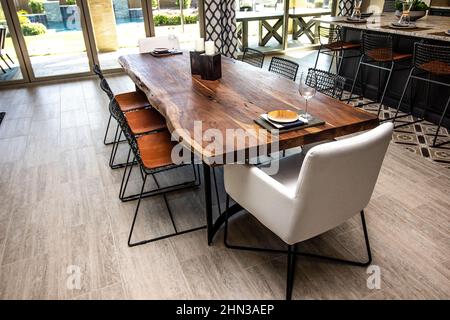 Unique Shaped Wooden Dining Area Table With Eight Chairs Stock Photo