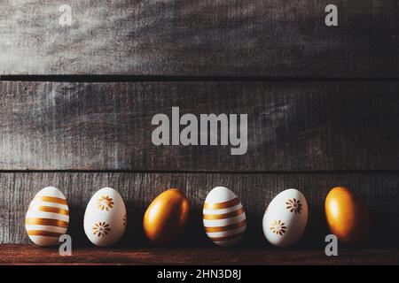 Easter holiday conceptual background on rustic wooden boards. Top view from above to different Easter eggs flat lay. Card with copy space to place text. Minimal concept. High quality photo Stock Photo
