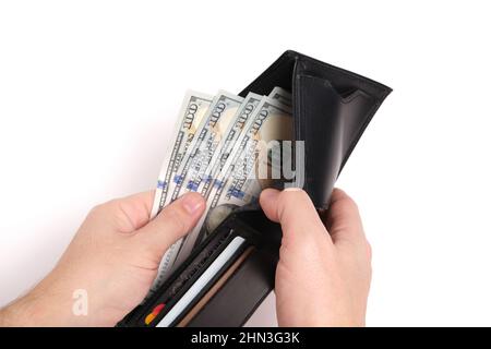 Black leather wallet in hands with stack hundred dollar bills and bank cards on white background.Concept wealth and affluence Stock Photo