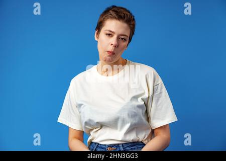 Young short-haired woman with weird expression iin studio Stock Photo