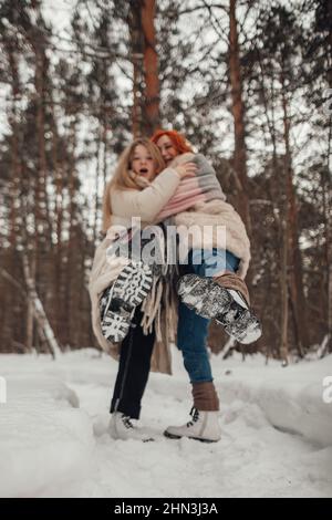 Two girls having fun in the winter forest Stock Photo