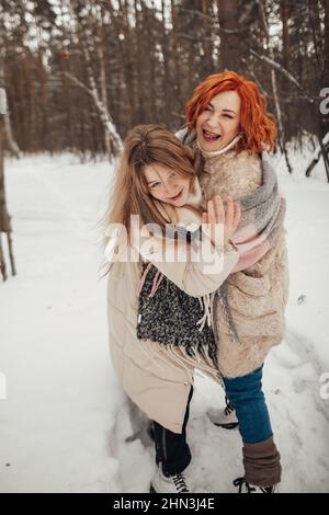 Two girls having fun in the winter forest Stock Photo