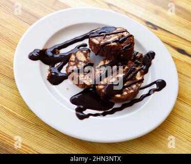 Sweet chocolate sausage of nuts and cookies with glaze Stock Photo