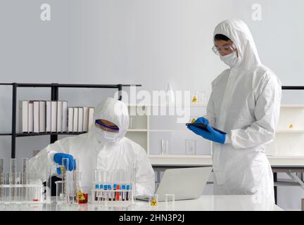 Epidemiological researcher in virus protective cloth working in laboratory. Omicron strain testing process, Coronavirus disease 2019. Stock Photo