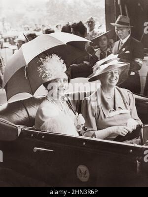 Vintage photo of Mrs. Eleanor Roosevelt and Queen Elizabeth, holding umbrella, in automobile, leaving station for the White House. USA. 1930s Stock Photo