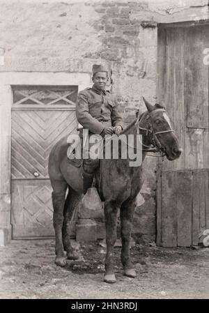 USA in World War I. African American soldier in uniform with handgun in holster riding a horse. 1917-1918 Stock Photo