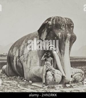 Vintage photo of young Chinese herd near ancient Chinese sculpture of a kneeling stone elephant. The Ming Tombs. North China. 1902 Stock Photo