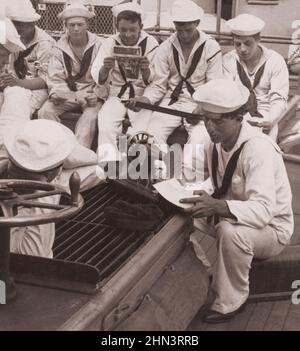 Vintage photo of World War I. 1914-1918. A sailor's sewing day reminds him keenly of home and mother. Life on board a US battleship Stock Photo