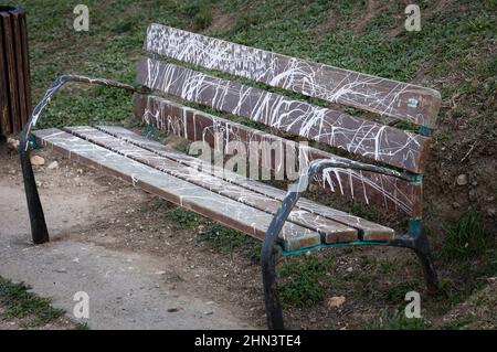 Vandalised bench covered in spray paint Stock Photo