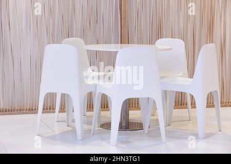 White chairs and table indoor set. Contemporary comfortable plastic furniture Stock Photo