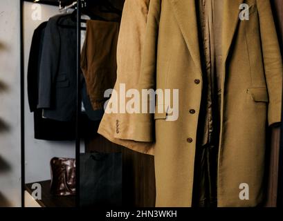 Row of fashion clothes of different colors clothing on hangers. Retail. Stylish coat Stock Photo