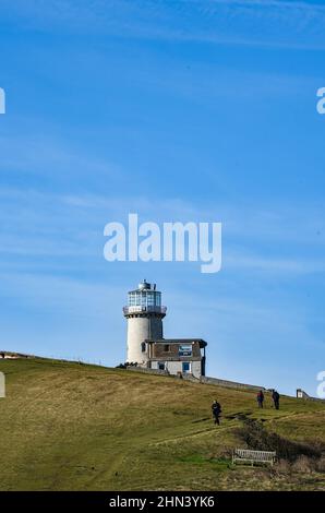 Walkers near the Belle Tout lighthouse now an unusual home which  on the cliffs at Beachy Head , Eastbourne , Sussex England UK Stock Photo