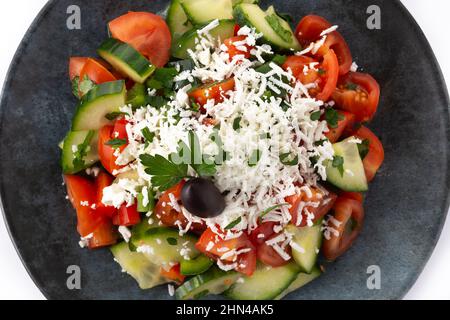 Traditional Bulgarian shopska salad with tomato,cucumber and bulgarian sirene cheese isolated on white background Stock Photo