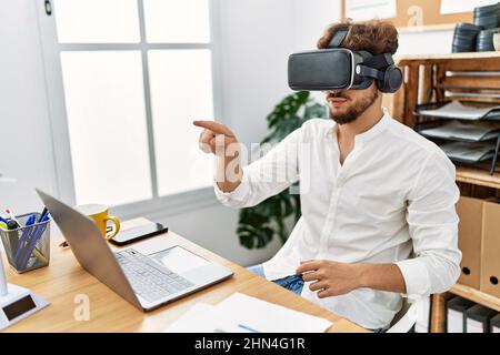 Young arab man using vr goggles working at office Stock Photo