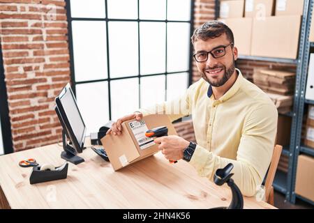 Young hispanic man ecommerce business worker scanning label using barcode reader at office Stock Photo