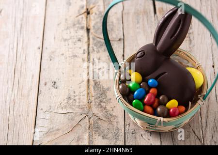 Easter chocolate bunny and colorful eggs on wooden table Stock Photo