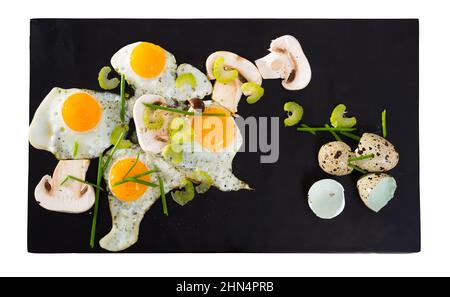 Fried quail eggs with champignons Stock Photo