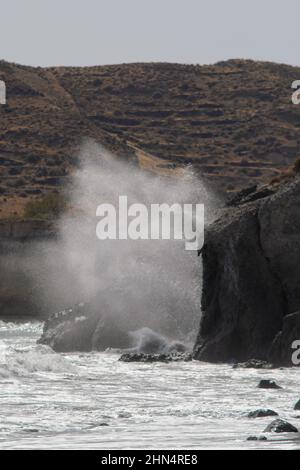 Big waves crushing on rocks at the famous red beach in Santorini Greece Stock Photo