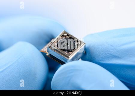 Cell phone single camera module in scientist hands Stock Photo