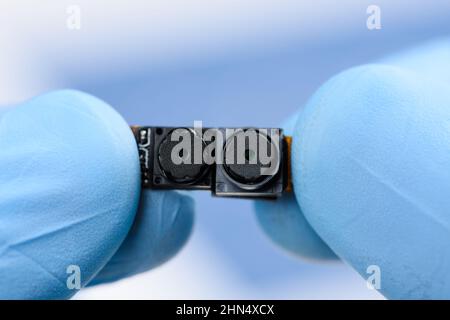 Two camera modules in scientist hands. Smartphone sensor research or repair concept. Stock Photo