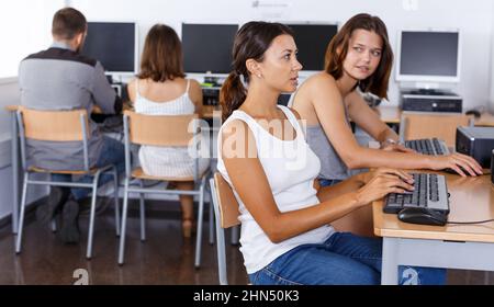 Girls using pc in library Stock Photo - Alamy