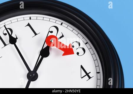 Summer time change for daylight saving in Europe concept. Red arrow symbolizing clock turned forward by one hour Stock Photo