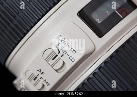 Fragment of a lens with focus mode switches, distance limiter and distance scale Stock Photo