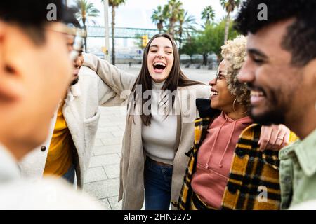 Group of multiracial friends talking and laughing in city street Stock Photo