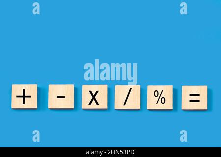 Mathematical marks in wooden blocks on a blue background with copy space Stock Photo