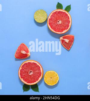 Creative exotic copy space background with citrus grapedruits, lemon and lime with green leaves. Flat lay minimal. Stock Photo