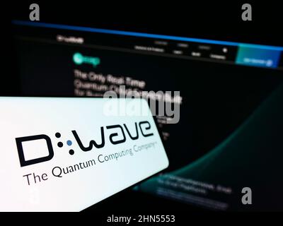 Smartphone with logo of Canadian hardware company D-Wave Systems Inc. on screen in front of business website. Focus on left of phone display. Stock Photo