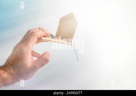 Bank investments and risks. A man's hand was caught in a mousetrap with a schematic cardboard house. In the background, heaven and light. Copy space. Stock Photo