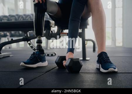 Close up of disabled man with prosthetic leg doing bicep curls Stock Photo