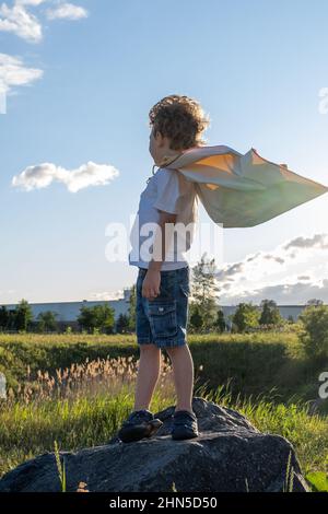 Young boy looking at horizon with a superhero cape. High quality photo Stock Photo