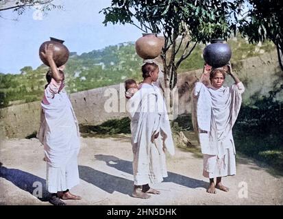 Machine Colourised Water Carriers, Antananarivo, Madagascar from the book '  The living races of mankind ' Vol 1 by Henry Neville Hutchinson,, editors John Walter Gregory, and Richard Lydekker, Publisher: London,  Hutchinson & co 1901 Stock Photo